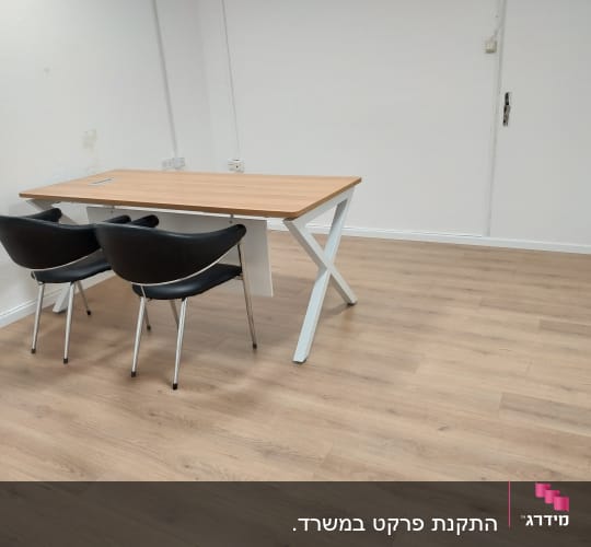 רצפת פרקט עץ בהירה בחדר ריק עם שולחן